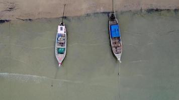 Aerial view from a drone of Thai traditional longtail fishing boats sailing in the sea. Top view of a fishing boat in the ocean. video