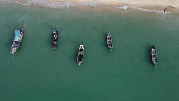 Aerial view from a drone of Thai traditional longtail fishing boats sailing in the sea. Top view of a fishing boat in the ocean. video