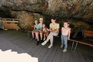 madre con hijos sentarse en un banco en liechtensteinklamm o garganta de liechtenstein, austria. foto