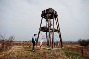 Children against wooden observation tower. photo