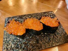 Japanese food called Ikura Onigiri, salmon roe roll wrapped in seaweed. photo