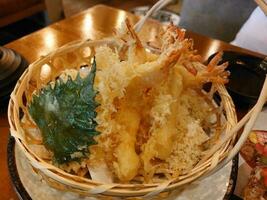 tempura de gambas y shiso verde se sirven en una cesta en el restaurante. foto