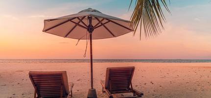 Beautiful panoramic beach. Chairs umbrella sandy beach, palm leaves seascape. Summer holiday vacation tourism. Amazing tropical landscape. Tranquil scenery, relaxing beach, tropical landscape panorama photo