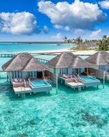 Maldives paradise island. Tropical aerial landscape, seascape with pier, water bungalows villas with amazing sea lagoon beach. Exotic tourism destination, summer vacation background. Aerial travel photo