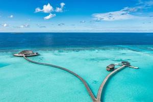 Maldives paradise island. Tropical aerial landscape, seascape pier pathway, water bungalows villas with amazing sea lagoon beach. Exotic tourism destination, summer vacation background. Aerial travel photo