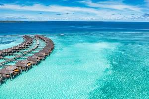 Maldives paradise island. Tropical aerial landscape, seascape pier pathway, water bungalows villas with amazing sea lagoon beach. Exotic tourism destination, summer vacation background. Aerial travel photo