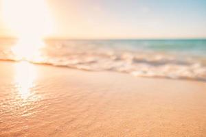 olas de primer plano y arena de mar, paisaje de playa paraíso. inspirar el horizonte del paisaje marino de la playa tropical. cielo anaranjado y dorado de la puesta de sol, calma borrosa, verano tranquilo y relajante. vacaciones viajes vacaciones foto