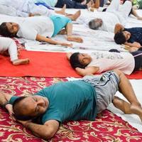 New Delhi, India, June 19 2022 -Group Yoga exercise session for people of different age groups in Balaji Temple, Vivek Vihar, International Yoga Day, Big group of adults attending yoga class in temple photo