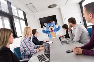 boss dresed as bear having fun with business people in trendy office photo