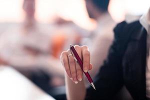 woman hands holding pen on business meeting photo