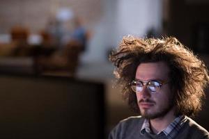 hombre trabajando en una computadora en una oficina oscura foto