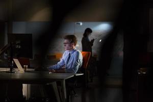 man working on computer in dark office photo