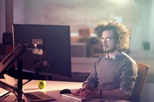 hombre trabajando en una computadora en una oficina oscura foto