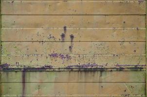 Texture of an old orange metal wall with significant damage from exposure to unfavorable weather conditions and dampness photo