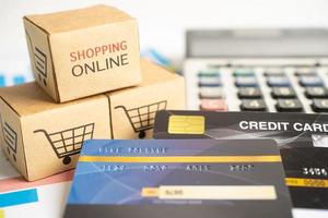 Shopping online box with credit card and calculator on graph. Finance commerce import export business concept. photo