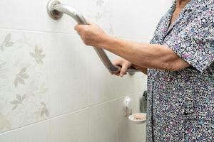 Asian senior or elderly old lady woman patient use toilet bathroom handle security in nursing hospital ward, healthy strong medical concept. photo