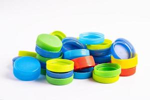 Plastic bottle colored screw caps for recycle waste on white background, container water lid. photo