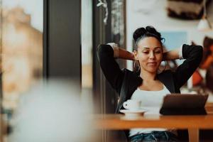 a latino woman sitting in a cafe on a break from work photo