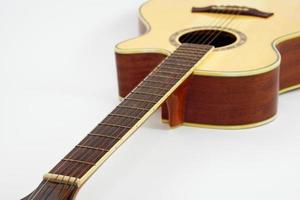 An acoustic guitar on white background with copy space and selective focus.