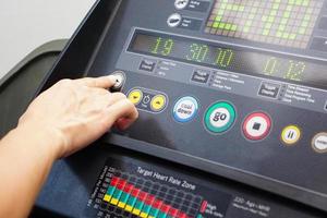 Close up of hand selecting a function from the treadmill. photo