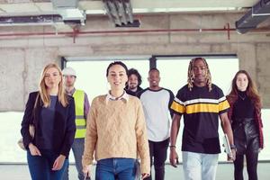 young multiethnic business people walking through unfinished startup office photo