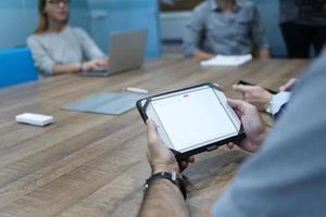 close up of businessman on meeting using tablet photo