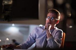 man working on computer in dark office photo