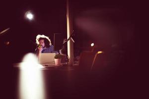 man working on computer in dark office photo