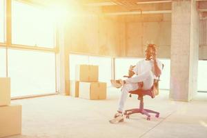 young casual black businessman using mobile phone on construction site photo