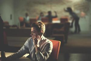 man using mobile phone in dark office photo