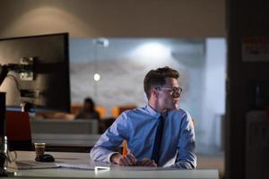 man working on computer in dark office photo