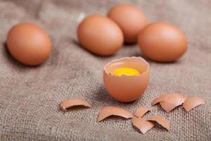 huevos frescos en saqueo, cáscara de huevo rota, yema foto