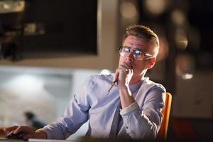 man working on computer in dark office photo