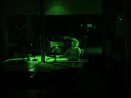 man working on computer in dark office photo