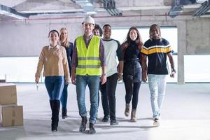 young multiethnic business people walking through unfinished startup office photo