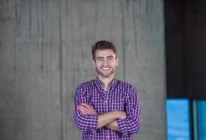 portrait of casual businessman in front of a concrete wall photo