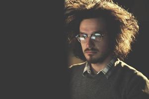 man working on computer in dark office photo