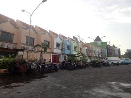 several motorbikes are parked on the edge of the Mutiara Marina shophouse photo