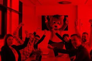 boss dresed as bear having fun with business people in trendy office photo