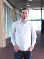 retrato de un joven hombre de negocios con barba en una oficina moderna foto