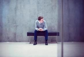 hombre de negocios que usa un teléfono inteligente mientras está sentado en el banco foto