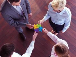 business people group assembling jigsaw puzzle photo