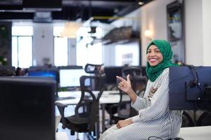 portrait of african muslim business woman sitting on desk photo