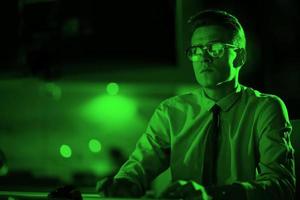 man working on computer in dark office photo