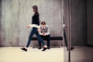 businessman using mobile phone while sitting on the bench photo