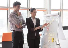 young couple working on flip board at office photo