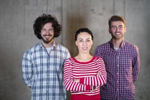 portrait of casual business team in front of a concrete wall photo