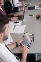 close up of  businessman hands  using tablet on meeting photo