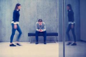 businessman using mobile phone while sitting on the bench photo