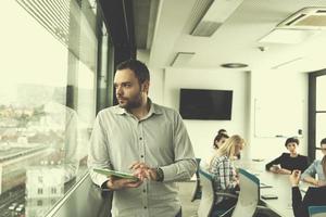 Businessman Using Tablet In Office Building by window photo